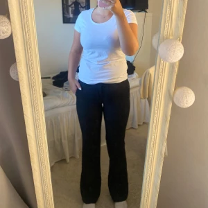 Svarta kostymbyxor från BikBok - Snygga svarta lågmidjade kostymbyxor från BikBok i storlek 36. Byxorna har bootcut modell och diskreta bakfickor och stängs med både knapp och hake. Perfekta för en clean och stilren look. 