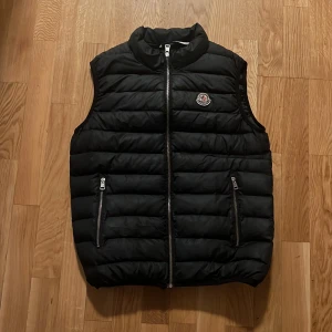 Moncler väst - Moncler väst som hittades under förrådsrensning, har inget garanti på äkhet därmed billigt pris, men kvalitet samt loga ser felfria ut. Västen är i bra skick, inte mycket slitage. Passar mig bra som är 182. 