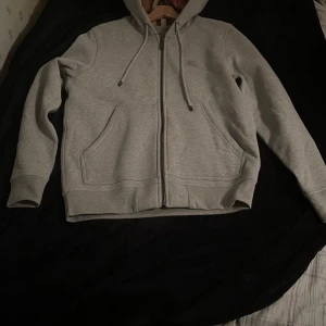 Grå hoodie från Burberry med dragkedja - Snygg grå hoodie ifrån burberry. Inte min stil därför säljer jag denna fina vara. Den är knappt rörd. Bara testad. Taggen ligger kvar.  PRIS KAN DISKUTERAS!!