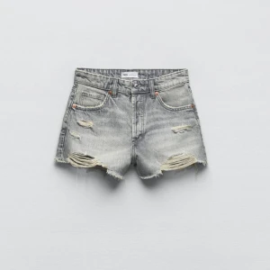 Grå jeansshorts - Grå jeansshorts från Zara med slitna detaljer och medelhög midja. shortsen är i mycjet bra skick och säljs endast för att de är lite för stora för mig. 