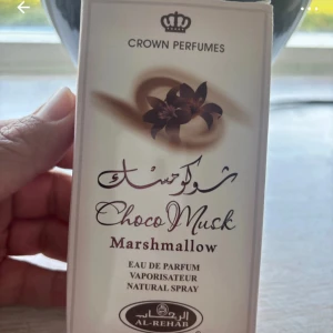 Choco Musk Marshmallow parfym 50ml - Söt och krämig Eau de Parfum från Al-Rehab med doft av choklad, mysk och marshmallow. Flaskan rymmer 50 ml och kommer i en ljusbeige kartong med bruna detaljer och blommotiv. Perfekt för dig som gillar gourmanddofter med en mjuk och varm känsla.