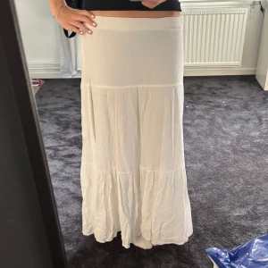 Lång vit kjol - Super fin lång kjol som du både kan klä up och ner! Den går ner till fötterna på mig som är 166 cm lång. Inga defekter och knappt använd💓