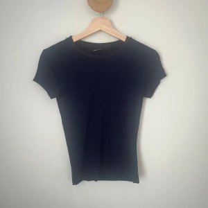 Marinblå t-shirt från Gina Tricot - En basic marinblå t-shirt från Gina Tricot i storlek S. Modellen är figurnära med korta ärmar och rund halsringning. Har använts några gånger men är i fint skick. 