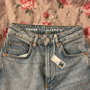Ljusblå raka jeans från Never Denim - Snygga ljusblå jeans från Never Denim med raka ben och klassisk femficksdesign. Hög midja och stilrena detaljer med Fairtrade-märkning. Perfekta för dig som gillar en clean och tidlös look. Materialet är 100% bomull för en skön känsla. Köpte för 600kr men säljer för 300kr säljer den för att det inte riktig är min still men super fint material ändå. 