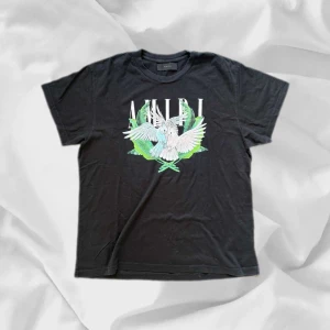 Amiri T-shirt - Snygg T-shirt från Amiri i svårt färg – enkel att matcha och skön att bära. Ett stilrent val, noggrant utvalt med omsorg av AM Clothing.  📩 Frågor? Hör gärna av dig! 📲 Följ oss här på Plik för fler uppdateringar. ♻️ Tack för att du handlar mer hållbart med AM Clothing!