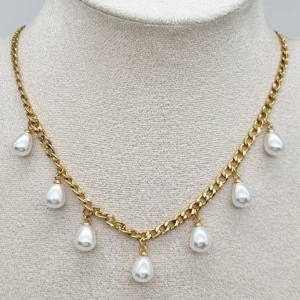 Guldhalsband med droppformade pärlor - Stilrent halsband i guldtonad kedja med sju droppformade vita pärlor som hänger längs hela halsbandet. Perfekt för dig som vill ha en elegant och trendig accessoar med lite extra bling.