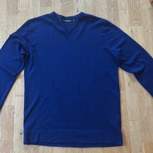 Blå v-ringad tröja från J.Lindeberg - Snygg marinblå v-ringad tröja från J.Lindeberg. Storlek L. Mycket bra skick