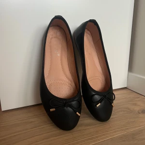 Svarta ballerinaskor med rosett - Jättefina ballerinaskor som inre är speciellt mycket använda då de snabbt blev för små. Köpte på Raglady och kom inte med någon box. 
