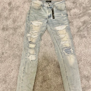 Amiri jeans - Säljer ett par ljusblå jeans från faygo dvs Amiri med skinny fit och slitna detaljer framtill. Skick 9/10. Storlek 30 vilket är S/M