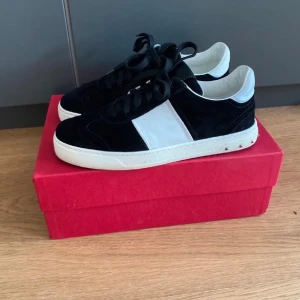 Valentino Garavani Flycrew svartvita sneakers - Ett par Valentino Flycrew sneakers i storlek 37,5  i fint skick, en nit saknas. Säljs tyvärr ej längre. Dustbag och kartong finns kvar, men inget kvitto. Nypris: på Farfetch kostade de 7800 kr.