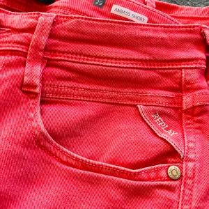 Coral jeansshorts från Replay Anbass  - Snygga korall jeansshorts från Replay, modell Anbass Short. Liten storlek, mer som 27/28 än 29.