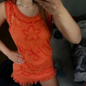 Orange klänning med volang - Superfin orange klänning med volangdetaljer och broderade blommor framtill. Perfekt för dig som gillar färg och unika detaljer. Har två stycken och båda finns att köpa på min profil, vill man köpa båda två kan man göra det tillsammans för ett bättre pris och bara betala frakt för 1❤️