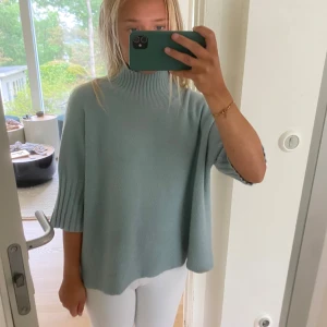 Ljusblå/turkos  stickad polotröja - Såsnygg tröja med en lätt polo och 3 kvarts ärmar. Snygg turkos färg. Märke: Alexander Laurent. Något nopprig och några enstaka fläckar som jag ej lyckats fá bort. Nypris 1200kr