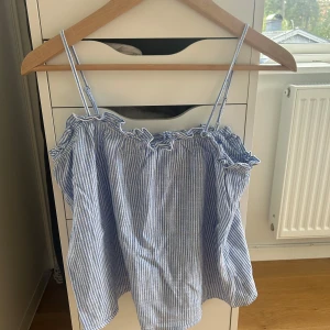 Blåvit randig linnetopp XS - Söt blåvit randig linnetopp med tunna axelband och volangdetalj upptill. Toppen har en luftig passform och är perfekt för varma dagar. Inte använd en enda gång - men köpte dock på plick. Inga defekter!💕
