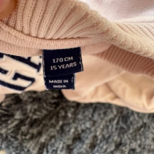 Beige sweatshirt från GANT - Säljer en beige sweatshirt från GANT med trycket 'GANT USA SINCE 1849' på framsidan. Tröjan har långa ärmar och ribbade muddar vid ärmslut och nederkant. Perfekt för en avslappnad stil. Den har en liten fläck men går säkert bort i tvätten innan jag skickar den
