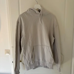 Vit hoodie från H&M - Säljer en vit hoodie från H&M. Den har en klassisk känguruficka och justerbar huva. 