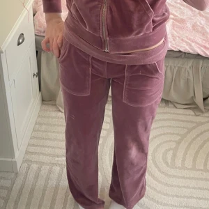 Rosa mjukisbyxor från 157 - Säljer ett par mysiga rosa mjukisbyxor från 157. Byxorna har en loose passform med elastisk midja och praktiska fickor fram. Perfekta för en avslappnad dag hemma eller en promenad i parken.