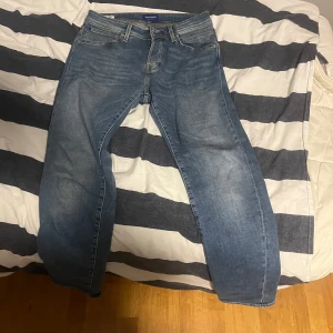 Blå jeans från Gant - Snygga blå jeans från Jack&Jones med klassisk femficksdesign och dragkedja. Perfekta för en avslappnad stil. De har en normal passform och är tillverkade i slitstarkt denim. 30/32 Tapered fit.