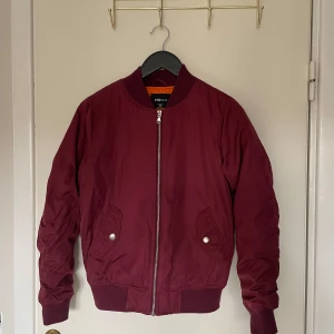 Vinröd bomberjacka - Vinröd bomberjacka, något fodrad/lite tjockare. 