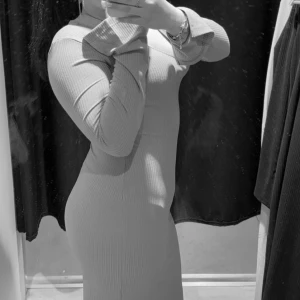 Ribbad klänning - Snygg ribbad klänning med lång ärm och figurnära passform. Perfekt för en stilren look.