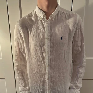 Vit linneskjorta från Ralph Lauren - Vit linneskjorta från Ralph lauren, köpt från kidsbrandstore. Riktigt skön passform och bra skick. Passar perfekt till sommaren. Den behöver strykas!