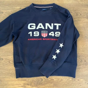 Mörkblå sweatshirt från GANT - Säljer en snygg sweatshirt från Gant. Tryck på bröstet och stjärnor på armen. Storlek L. Säljer för 200kr💗
