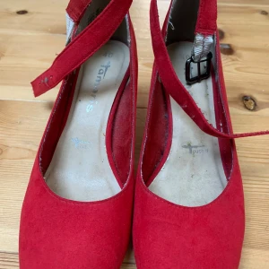 Klackar 👠  - Snygga röda pumps i mocka från Tamaris med en bekväm klack och justerbart spänne. Lite slitna vid skärpet syns dock inte när man har på sig de 