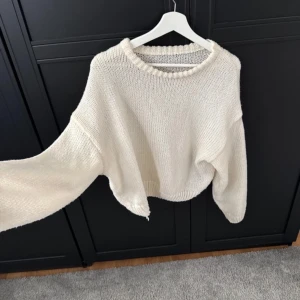 Vit stickad tröja - Säljer en mysig vit stickad tröja med en lös passform. Tröjan har långa ärmar och en rund halsringning med ribbade detaljer. Perfekt för kyliga dagar! Kontakta gärna för fler bilder med tröjan på 💕🌸