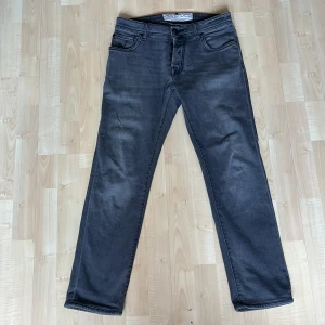 Grå jeans från Jacob Cohen - Snygga grå jeans från Jacob Cohen med en klassisk femficksdesign. De har en normal passform och är tillverkade i ett mjukt och bekvämt material. Perfekta för en stilren look.
