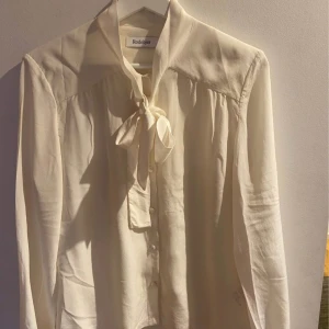 Sidenblus Rodebjer - Sidenblus med knyt framtill, färg : off white