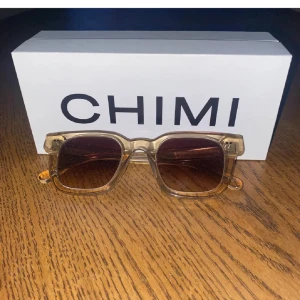 solglasögon Chimi - Snygga transparenta solglasögon från Chimi med fyrkantig form och mörka linser. Perfekta för en stilren look.