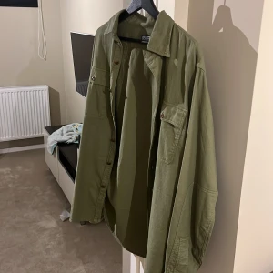 Olivgrön skjorta från Polo Ralph Lauren - Säljer en olivgrön overshirt från Polo Ralph Lauren, perfekt för en avslappnad stil. Säljer pågrund av att den inte används. Storlek M, påse och kvitto från där jag köpte den (Miinto) följer med. Hör av er om ni är intresserade. 