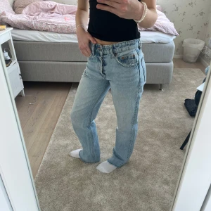 Ljusblå jeans från zara - Säljer ett par klassiska ljusblå zara jeans med en straight passform. De har en låg/medel midja och femficksdesign med knappgylf. 
