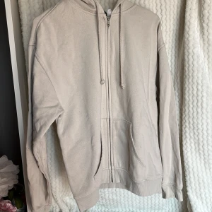 Beige hoodie från H&M🤍 - Säljer en beige hoodie från H&M:s Divided-kollektion. Den har dragkedja framtill och en klassisk känguruficka. Har lite små fläckar på armen.  🥥