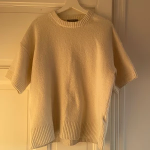 Vit stickad tröja från Gina Tricot - Säljer en stilren vit stickad tröja från Gina Tricot. Tröjan har korta ärmar och en ribbad kant vid halsen och nederkanten. 💞💞