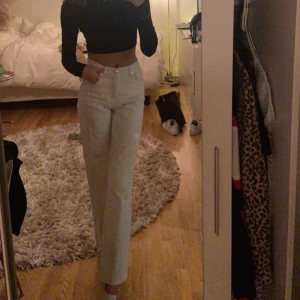 Vita jeansbyxor - Snygga vita jeansbyxor med hög midja och raka ben. Perfekta för en stilren look. De har klassisk femficksdesign och knappar i midjan.