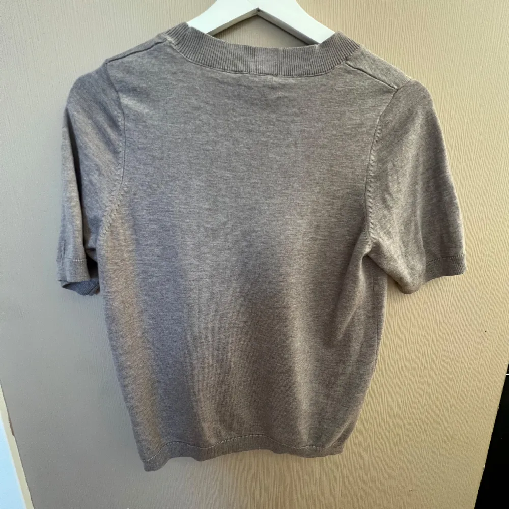 Säljer en stilren kortärmad tröja från Lindex. Perfekt för en avslappnad look. Tröjan har en rund halsringning och är tillverkad i ett mjukt material som ger en bekväm passform.. Neuletakit & Villapaidat.