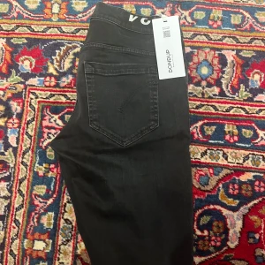 Svarta jeans från Dondup - Snygga svarta jeans från Dondup med en klassisk femficksdesign. De har en knappgylf och är tillverkade i ett stretchigt material för extra komfort. Perfekta för en stilren look.