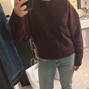 Helt ny Vinröd tröja från Zara  - Säljer en snygg vinröd tröja från Zara. Den har en klassisk rund hals och långa ärmar med ribbade muddar. Perfekt för kyligare dagar och ger en stilren look. Passar bra till jeans eller kjol.