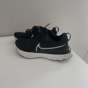 Svarta löparskor från Nike!  - Säljer ett par svarta löparskor/ gympaskor från Nike. Skorna har snörning, en bekväm passform och har stabilitet. Skorna är perfekta för löpträning annan typ av träning eller till vardagligt bruk. Sulan har ett unikt mönster för extra grepp. Säljer dessa bekväma skor då jag inte kan ha de längre. Nypris 1899 kr 