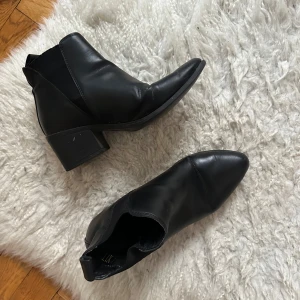 Svarta boots med klack - Snygga svarta boots i skinn med klack och spetsig tå. Perfekta för en stilren look.