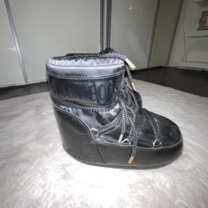 Svarta Moon Boots med snörning - Snygga och varma svarta Moon Boots med snörning. Perfekta för kalla vinterdagar. De har en hög design och är gjorda för att hålla fötterna varma och torra. Enkla att matcha med vintergarderoben. Jag köpte dom på Plick för ett tag sedan och då var dem i nyskick, efter det har jag haft dom ungefär ett år men dom har enbart kommit till användning en gång🖤jag har storlek 38 och dem passar men skulle kunna gissa att dom passar 37 och 39 också!