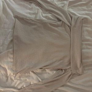 Beige offshoulder tröja från Gina Tricot - Säljer en stilren beige ribbad offshoulder tröja från Gina Tricot. Perfekt till sommarkvällar. Storlek  M, hör av dig vid intresse!🩷använd 3 ggr