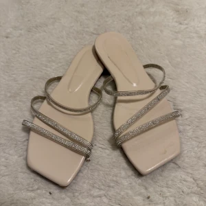 Beige sandaler med glittriga remmar - Ursnygga tofflor som piggar upp hela looken. 