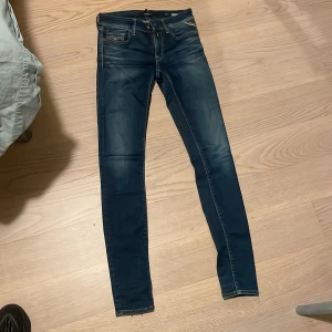 Mörkblå skinny jeans från Replay - Snygga mörkblå skinny jeans från Replay med klassisk femficksdesign och dragkedja. Perfekta för en stilren look. Märket Replay syns tydligt på insidan av midjan.
