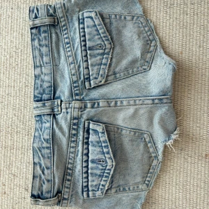 Jeansshorts från Pull&Bear - Säljer ett par coola jeansshorts från Pull&Bear. De är ljusblå med slitna detaljer och har praktiska fickor både fram och bak. Perfekta för en avslappnad stil.