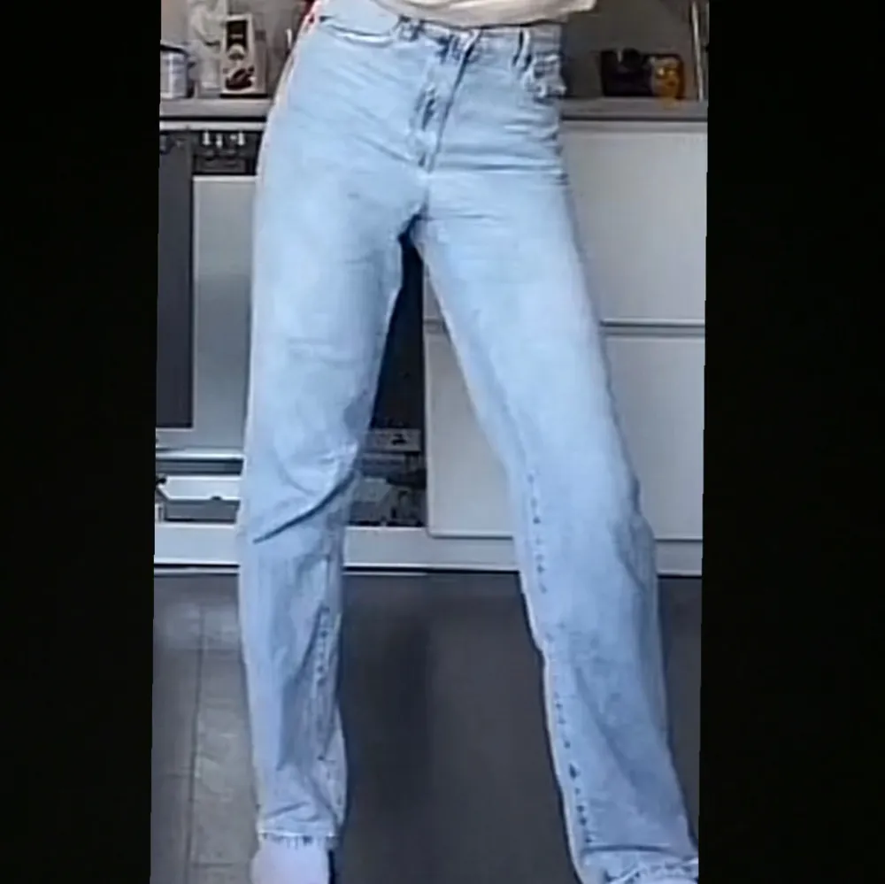 Snygga ljusblå jeans med hög midja och rak, lång passform. Perfekta för en avslappnad stil. De är ganska baggy och tunna i materialet. De har en defekt vid dragkedjan där vi behövt sy om, annars är de i bra skick.. Farkut & Housut.