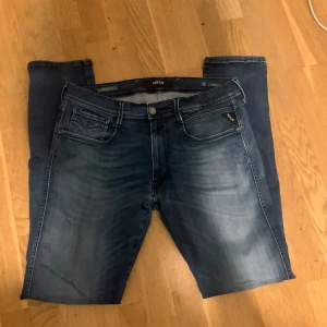 Blå jeans från Replay - Snygga blå jeans från Replay med en klassisk femficksdesign och dragkedja. De har en modern passform och är perfekta för en avslappnad stil. Jeansen har en lätt tvättad look som ger dem en cool vibe. Skick 8/10, nypris 1800 mitt pris 499, storlek 36/36 passar mig bra i längden som är 187 men är lite stora vid midjan men det beror också på vikten.