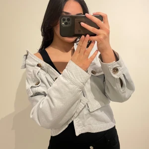 Ljusblå croppad jacka med knappar - Säljer en stilren ljusblå croppad jacka (färgen är lite tydligare i verkligheten). Går att styla på många olika sätt!