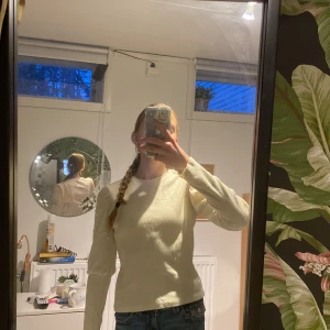 Vit ribbad tröja från Zara - Säljer en stilren vit ribbad tröja från Zara med långa ärmar och dekorativa pärlor på ärmarna. Perfekt för en elegant och bekväm look. Tröjan är gjord i ett mjukt material och har en klassisk rund halsringning.